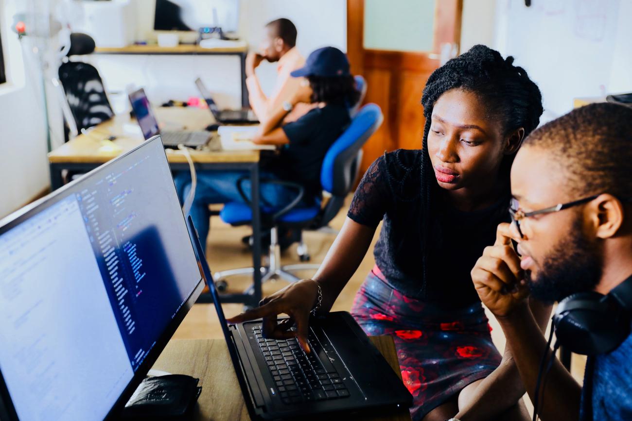 Two people working behind a computer